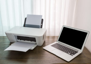 printer and laptop on wood table