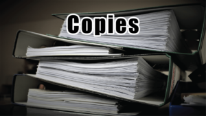 A stack of binders with copies in them on a table